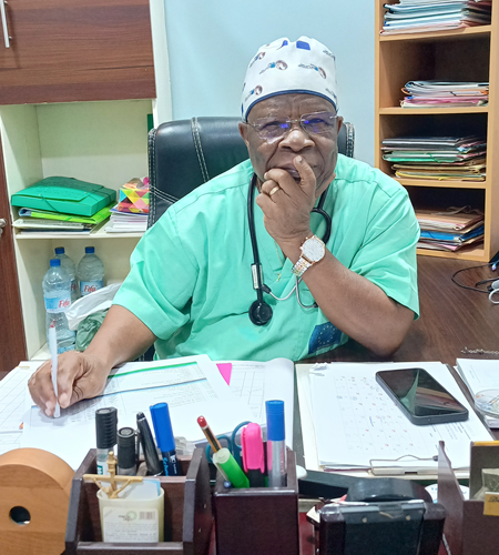Smiling african american doctor sitting at the table and talking by smartphone